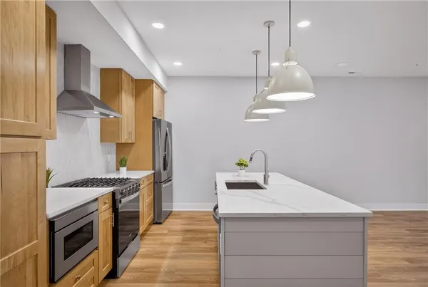 a kitchen with stainless steel appliances granite countertop a sink a stove and a refrigerator