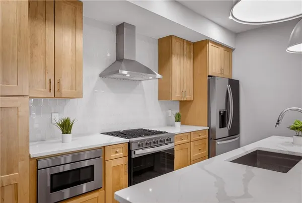a kitchen with stainless steel appliances a stove a refrigerator and a sink