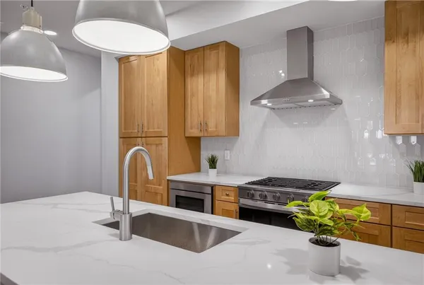 a kitchen with stainless steel appliances granite countertop a sink a stove and a wooden floors