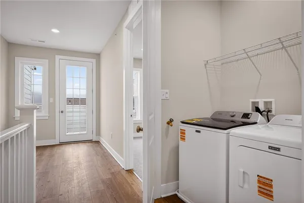 a view of a storage & utility room with closet wooden floor and windows