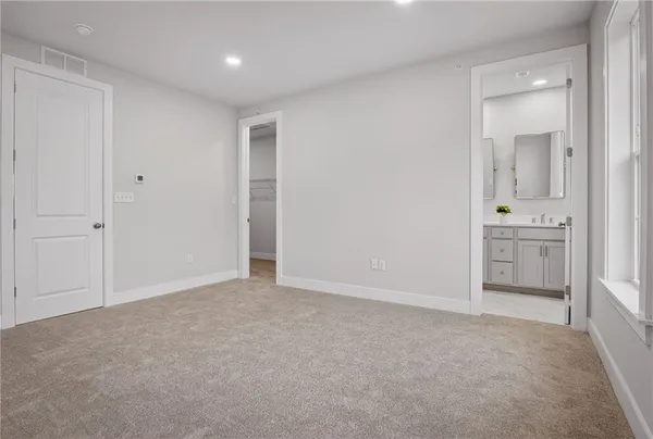 an empty room with a bathroom and mirror