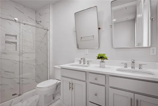 a bathroom with a sink a toilet and shower