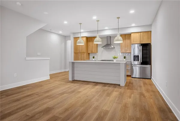 a large kitchen with stainless steel appliances a large counter top a stove and a refrigerator