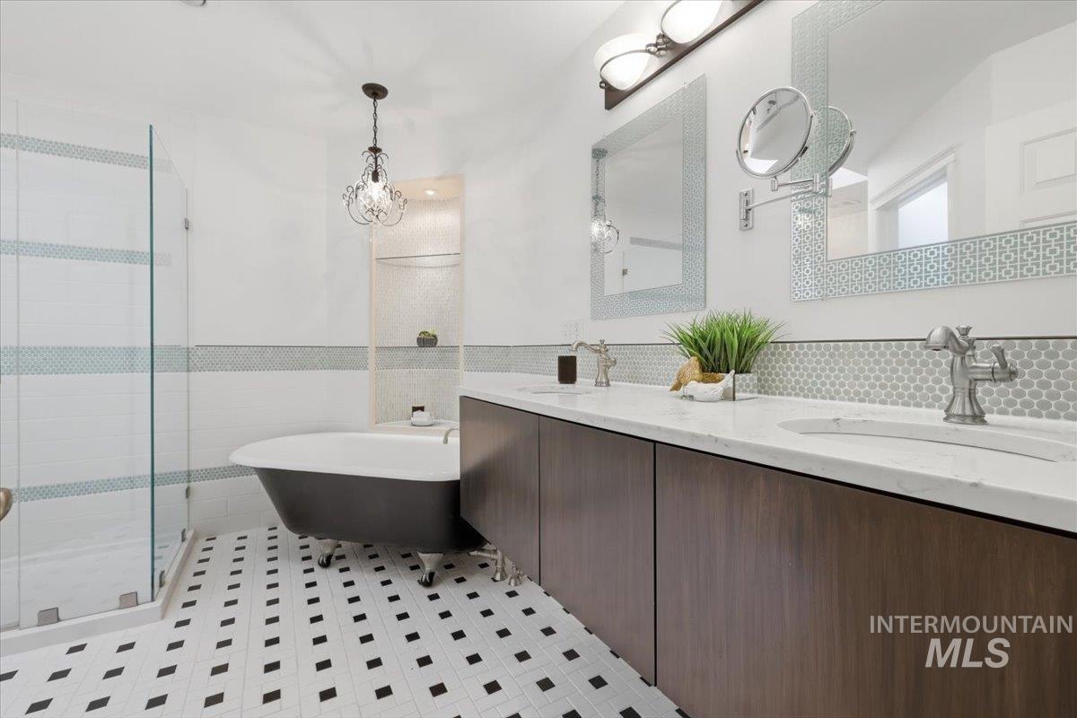 2075 North Springland Place Boise, ID 83713 - Photo 23 of 49 Bathroom featuring a freestanding clawfoot tub, a frameless glass shower enclosure, and a double vanity with wood-finish cabinetry