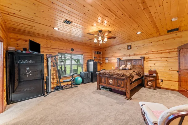 a bedroom with a bed and large windows