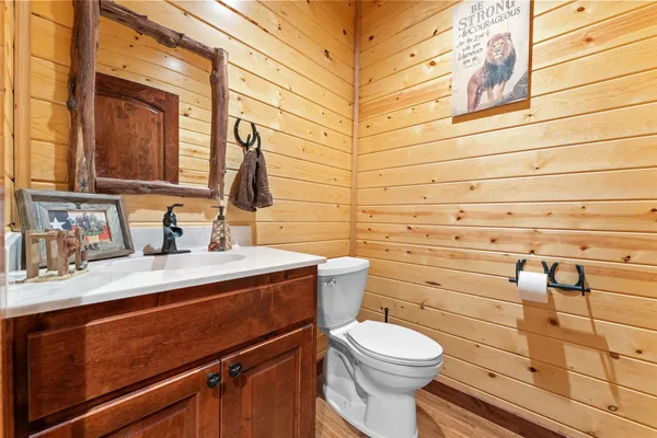 a bathroom with a granite countertop toilet sink and mirror