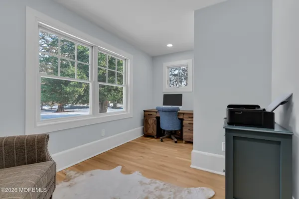 a view of a hallway with windows and hall with wooden floor