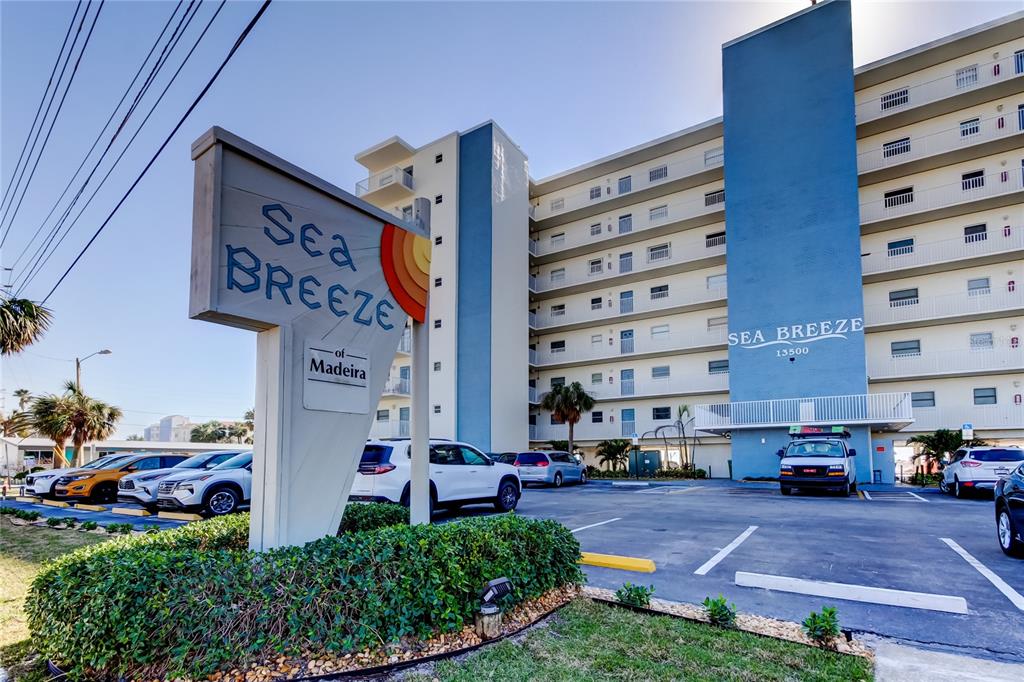 13500 Gulf Boulevard, Unit 702 Madeira Beach, FL 33708 - Photo 1 of 1 a front view of building with cars parked