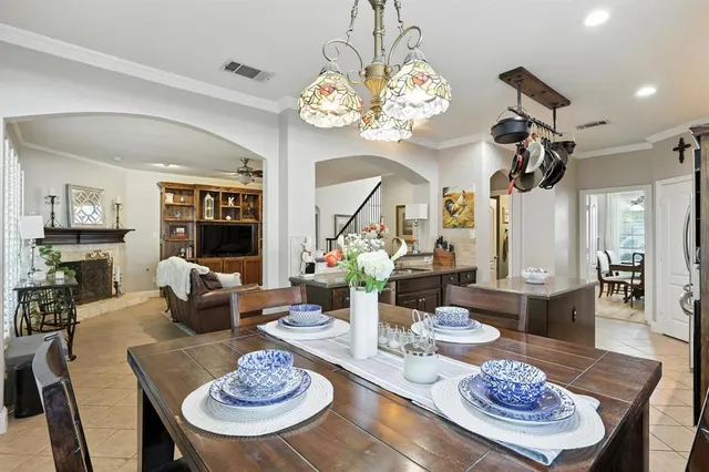 a living room with furniture a dining table and a chandelier