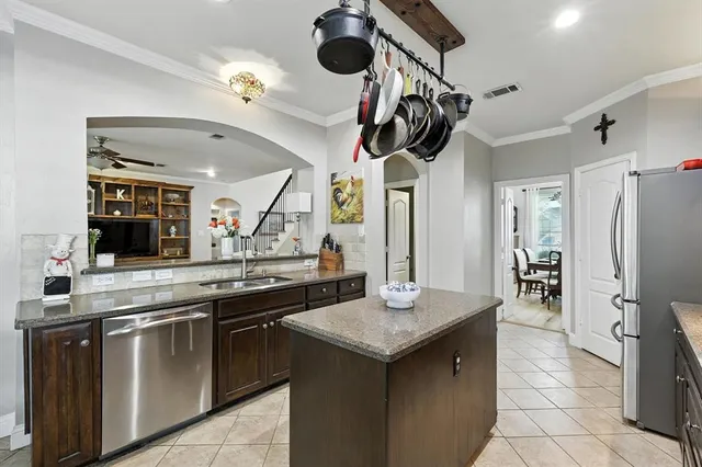 a kitchen with stainless steel appliances granite countertop a sink a stove and refrigerator