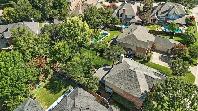 an aerial view of residential house with outdoor space and trees all around
