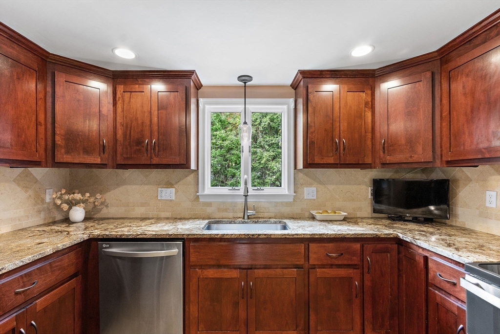 61 Pine Ridge Drive Franklin, MA 02038 - Photo 15 of 41 a kitchen with stainless steel appliances granite countertop wooden cabinets a sink and dishwasher next to a window