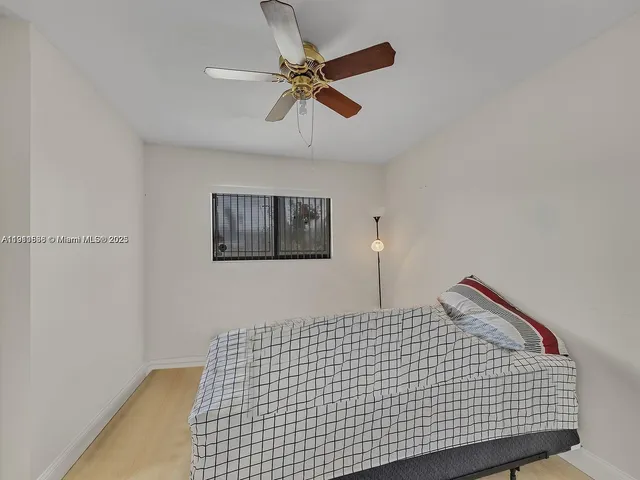 a bedroom with a bed and a ceiling fan