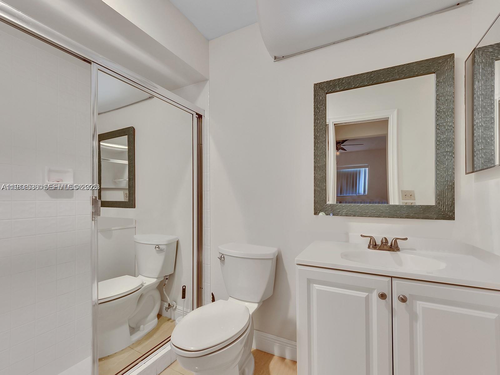 2701 Southwest 58th Manor, Unit B Dania Beach, FL 33312 - Photo 16 of 18 a bathroom with a toilet a sink a vanity and mirror