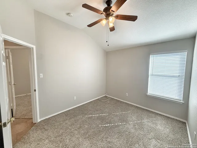 an empty room with fan and windows