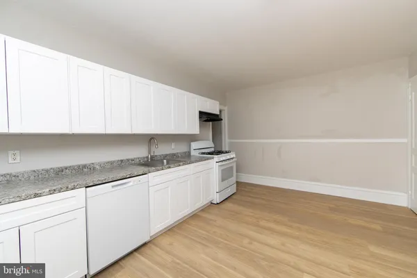 a kitchen with granite countertop a sink and a stove top oven