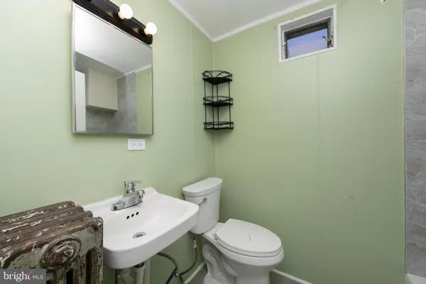 a bathroom with a sink a toilet and mirror
