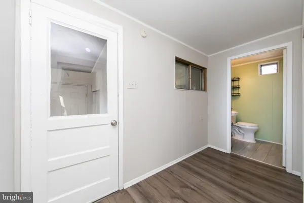 a view of a bathroom with wooden floor and a toilet