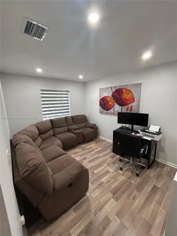 a living room with furniture and a hard wood floor
