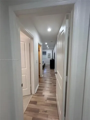 a view of a hallway with wooden floor