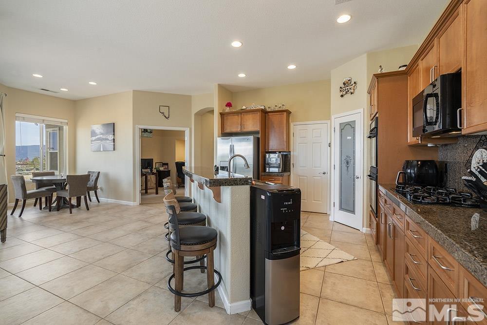 6840 Marble Canyon Road Reno, NV 89511 - Photo 6 of 39 a kitchen with stainless steel appliances granite countertop a refrigerator and a stove top oven