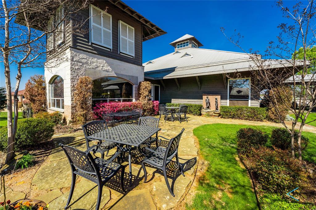 237 Colonial Drive Mabank, TX 75156 - Photo 13 of 20 a view of a patio with dining table and chairs under an umbrella with a small yard
