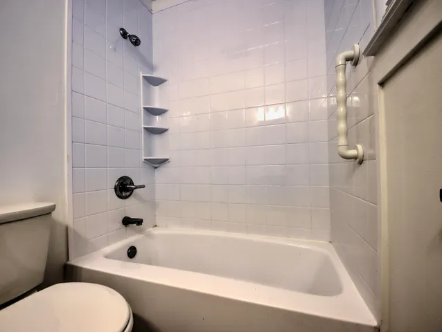 a bathroom with a bathtub and a toilet