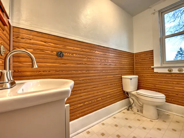 a bathroom with a toilet a sink and a window