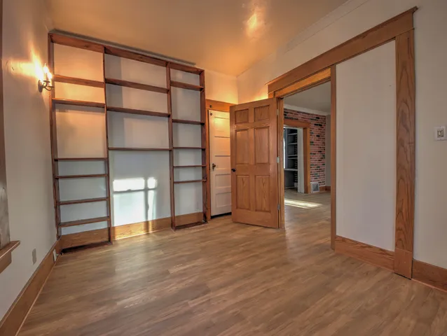 an empty room with wooden floor and closet