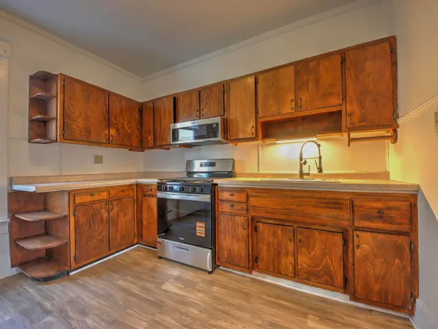a kitchen with stainless steel appliances granite countertop a stove a sink dishwasher and a microwave oven with cabinets