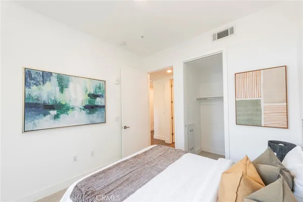 a bedroom with a bed and a painting on the wall