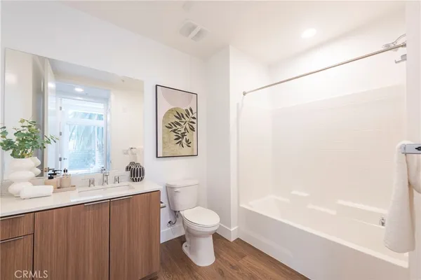 a bathroom with a sink a toilet and a large mirror