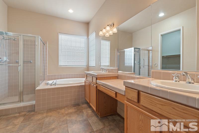 1630 Brightstone Court Reno, NV 89521 - Photo 14 of 27 a spacious bathroom with a granite countertop tub a double vanity sink a vanity a window and a mirror
