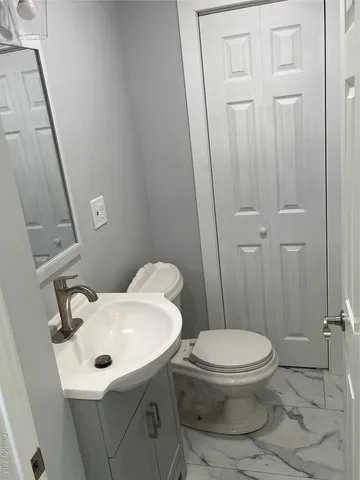 a white toilet sitting next to a bathroom sink