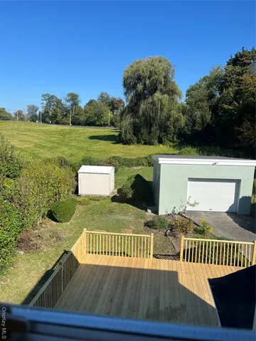 a view of a balcony with wooden floor and a floor to ceiling window