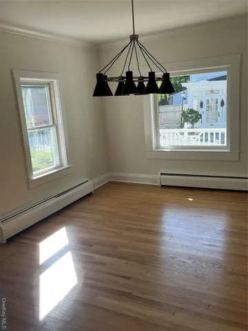 a view of a room with wooden floor chandelier and a window