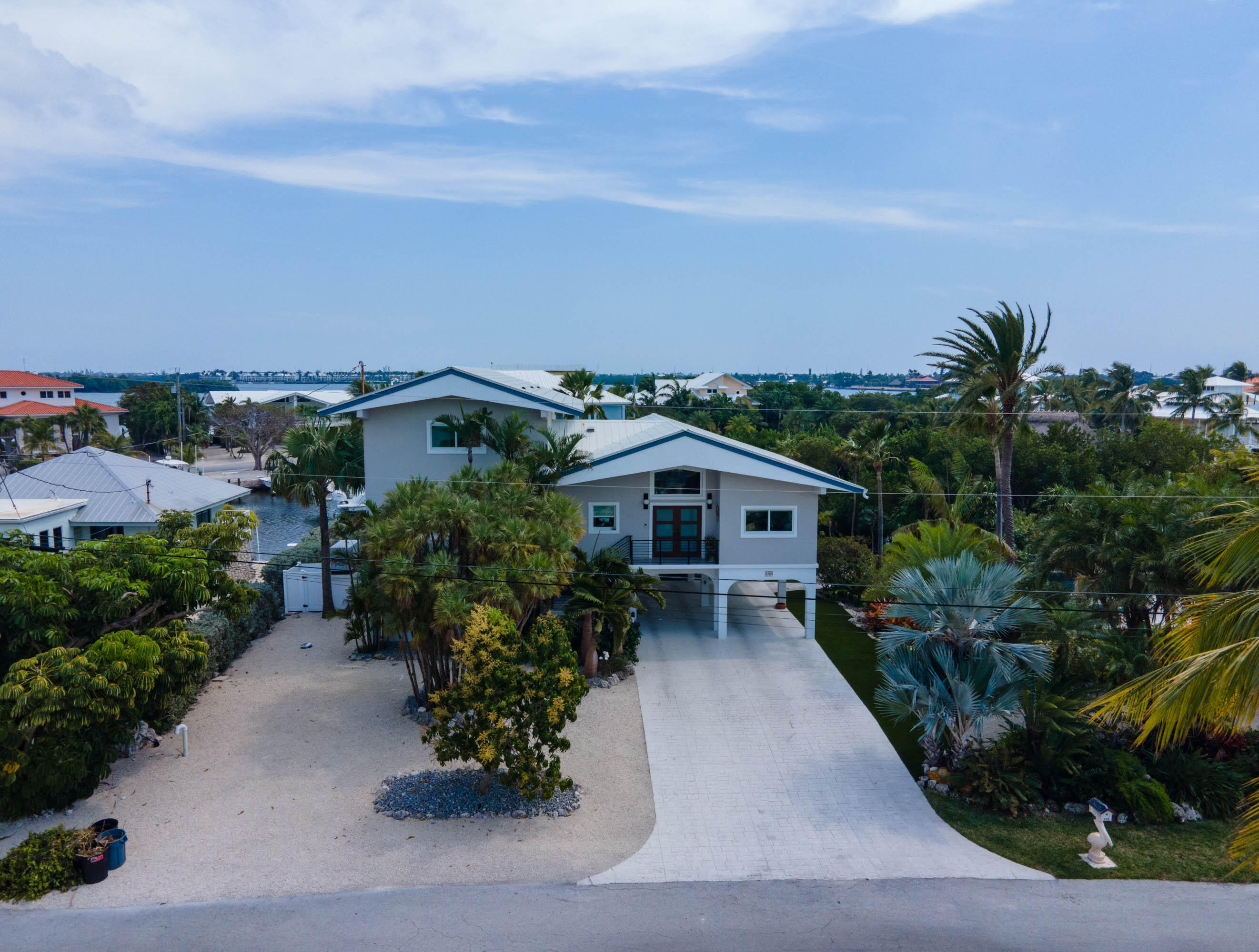 358 Stirrup Key Boulevard Marathon, FL 33050 - Photo 2 of 29 a front view of a house with a yard and potted plants