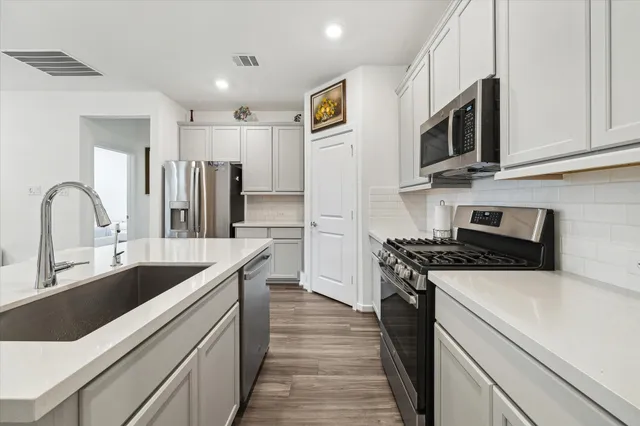a kitchen with stainless steel appliances granite countertop a sink stove and refrigerator