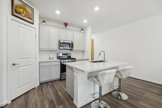 a kitchen with a sink a microwave a refrigerator and cabinets