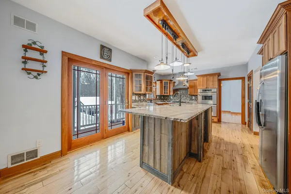 a kitchen with stainless steel appliances granite countertop a refrigerator a stove and a wooden floors