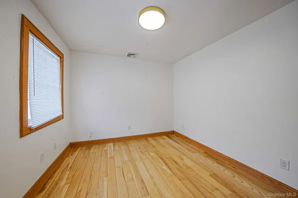 a view of a room with wooden floor and window