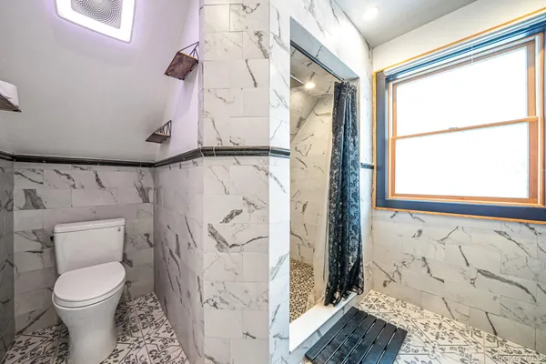 a bathroom with a toilet and a shower