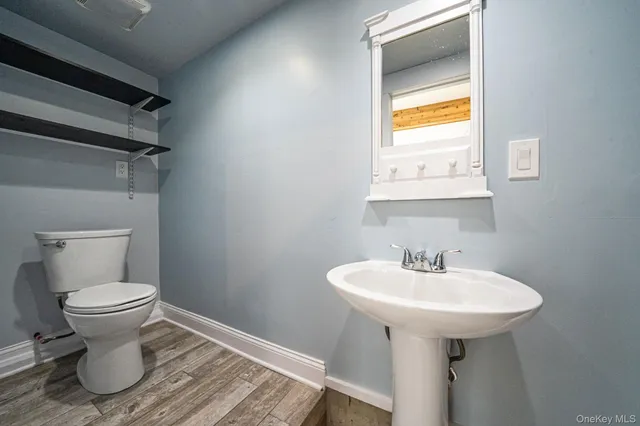 a bathroom with a sink toilet and a mirror