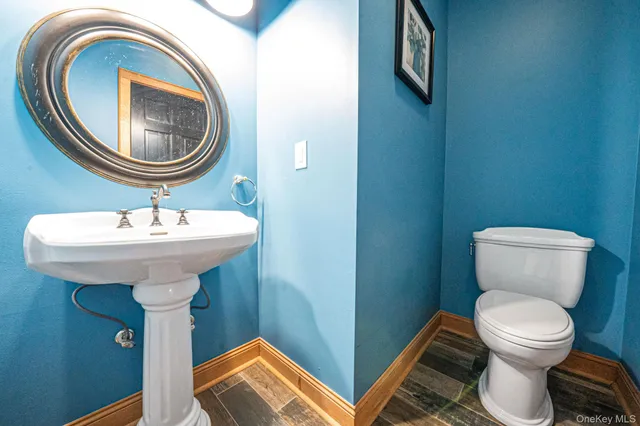 a bathroom with a sink a toilet and a mirror