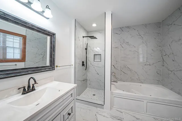 a bathroom with a granite countertop sink a toilet and shower