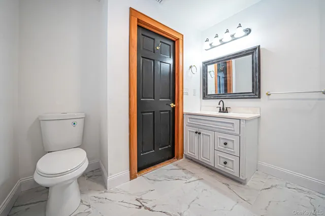 a spacious bathroom with a toilet sink and mirror