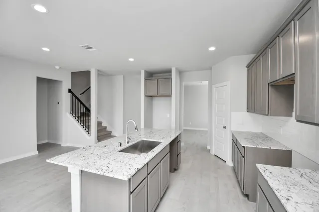 a kitchen with granite countertop a sink and a stove