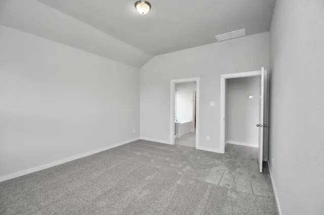 a spacious bedroom with a bed and a flat screen tv