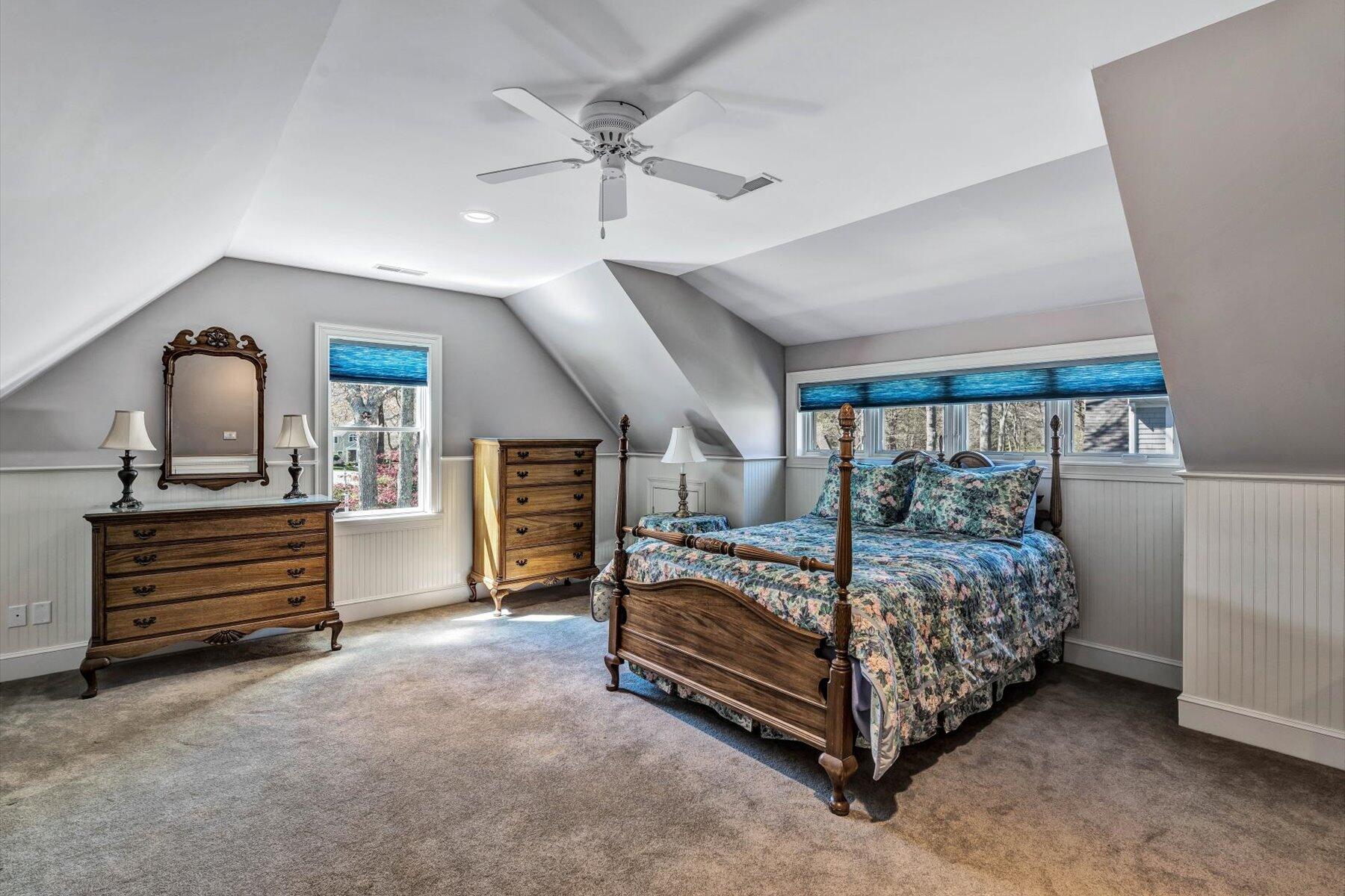 11 Reflection Drive Sandwich, MA 02563 - Photo 32 of 44 a bedroom with a bed and a chandelier