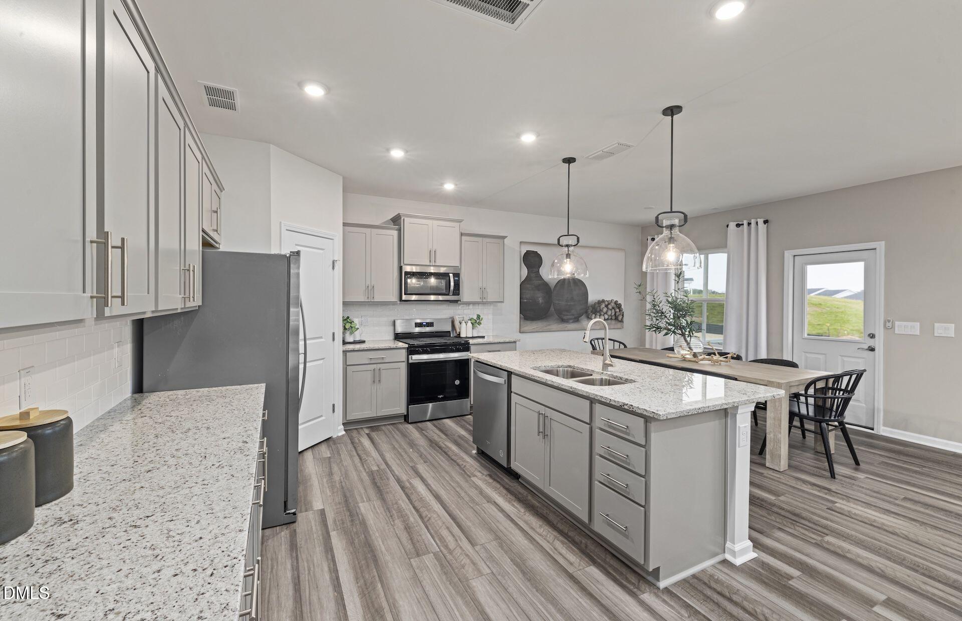 613 Ben Ledi Court Raleigh, NC 27603 - Photo 3 of 32 a kitchen with stainless steel appliances granite countertop a stove a sink dishwasher a refrigerator and white cabinets with wooden floor